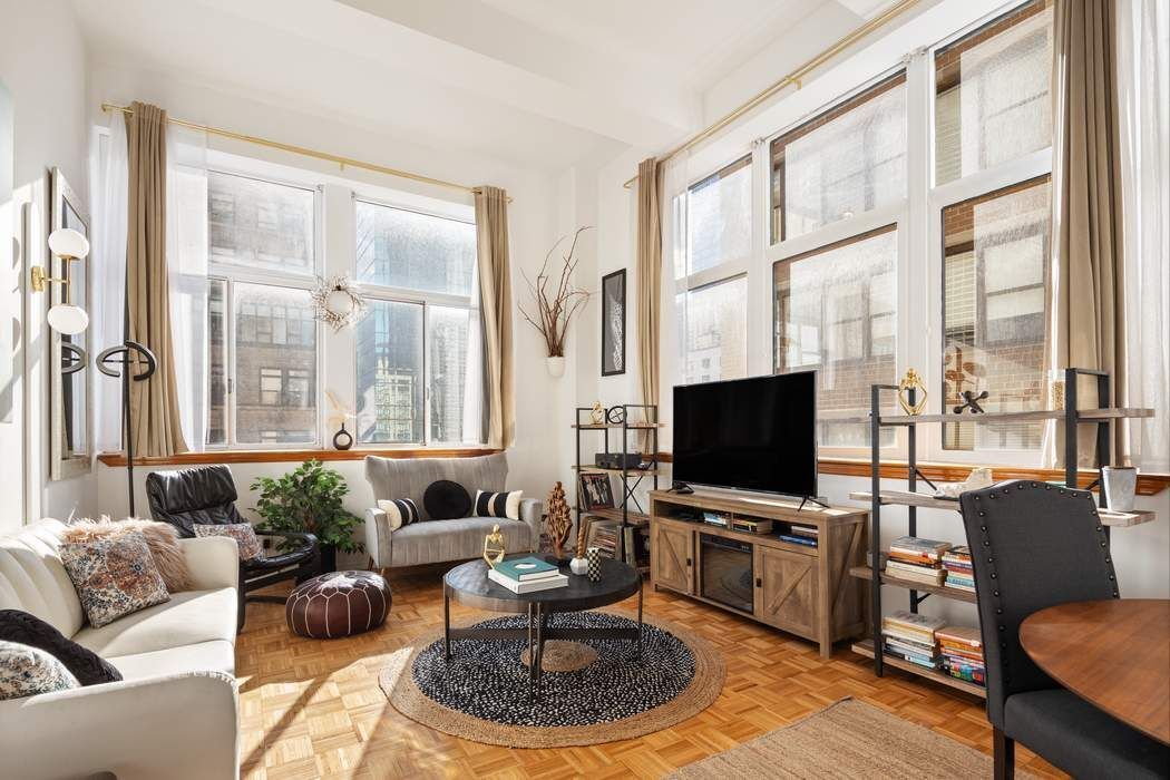 a living room with furniture tv and a large window