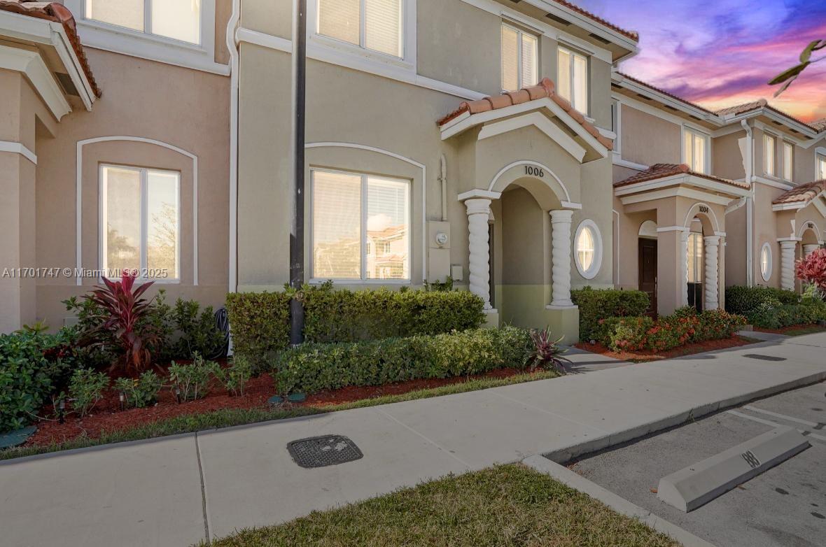 a front view of a house with yard and green space