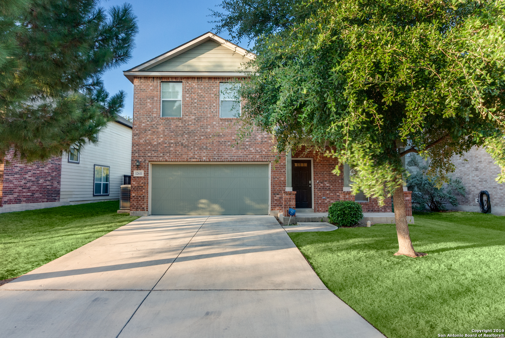 a front view of a house with a yard and trees