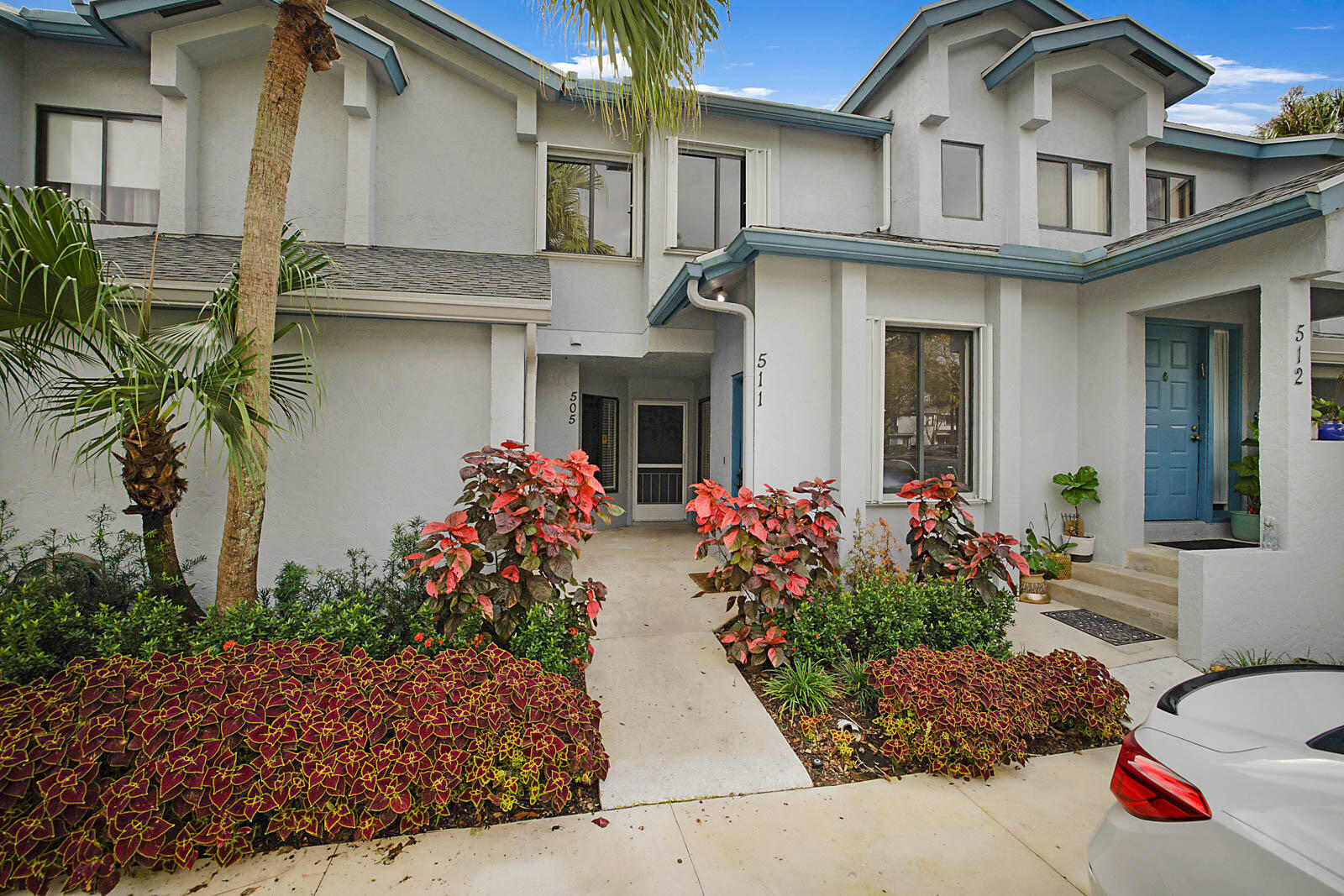 a front view of house and yard with beautiful flowers