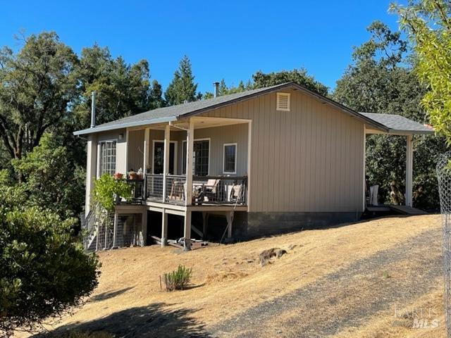 a front view of house with yard and trees in the background