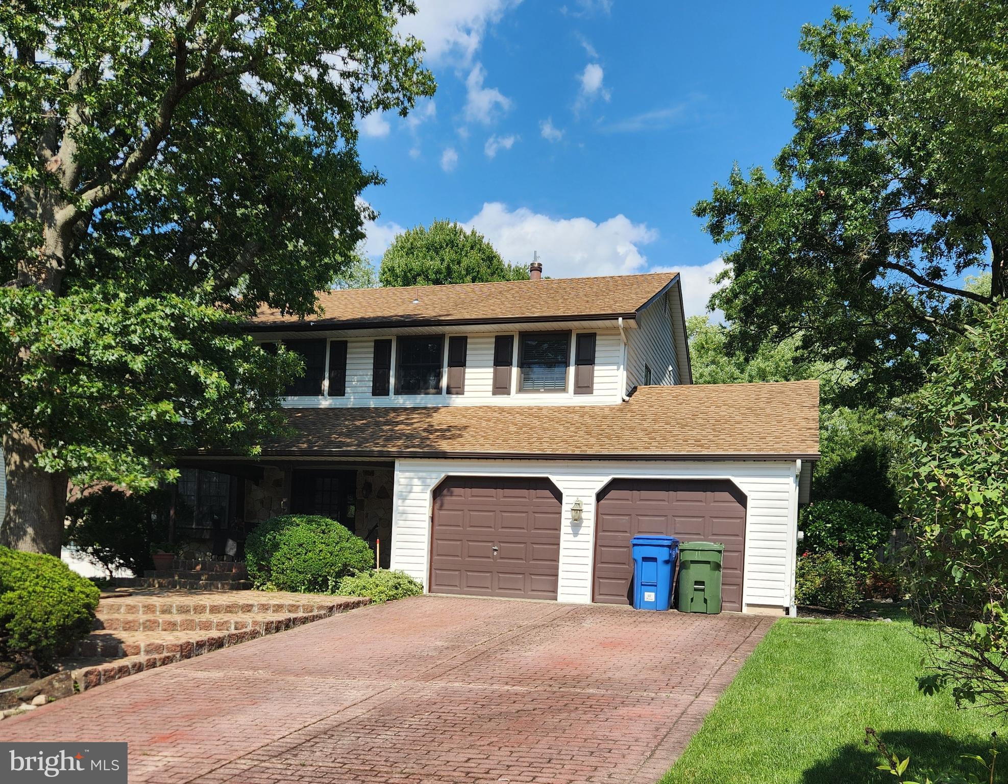 a front view of a house with yard and trees