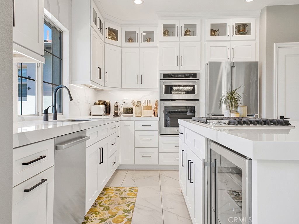 a kitchen with white cabinets and appliances