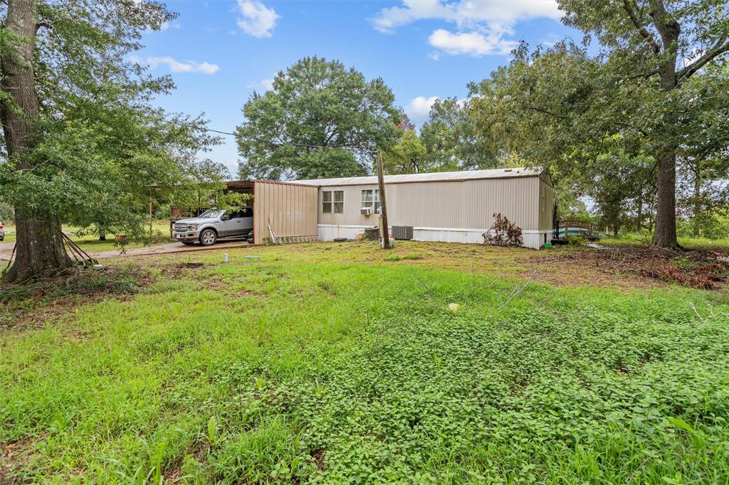 a view of a house with backyard and a tree