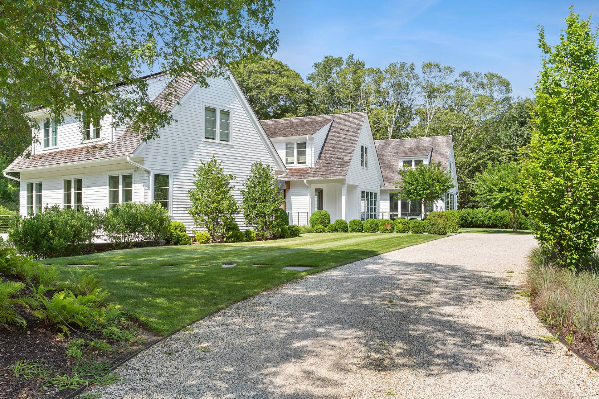 a front view of a house with a yard and trees