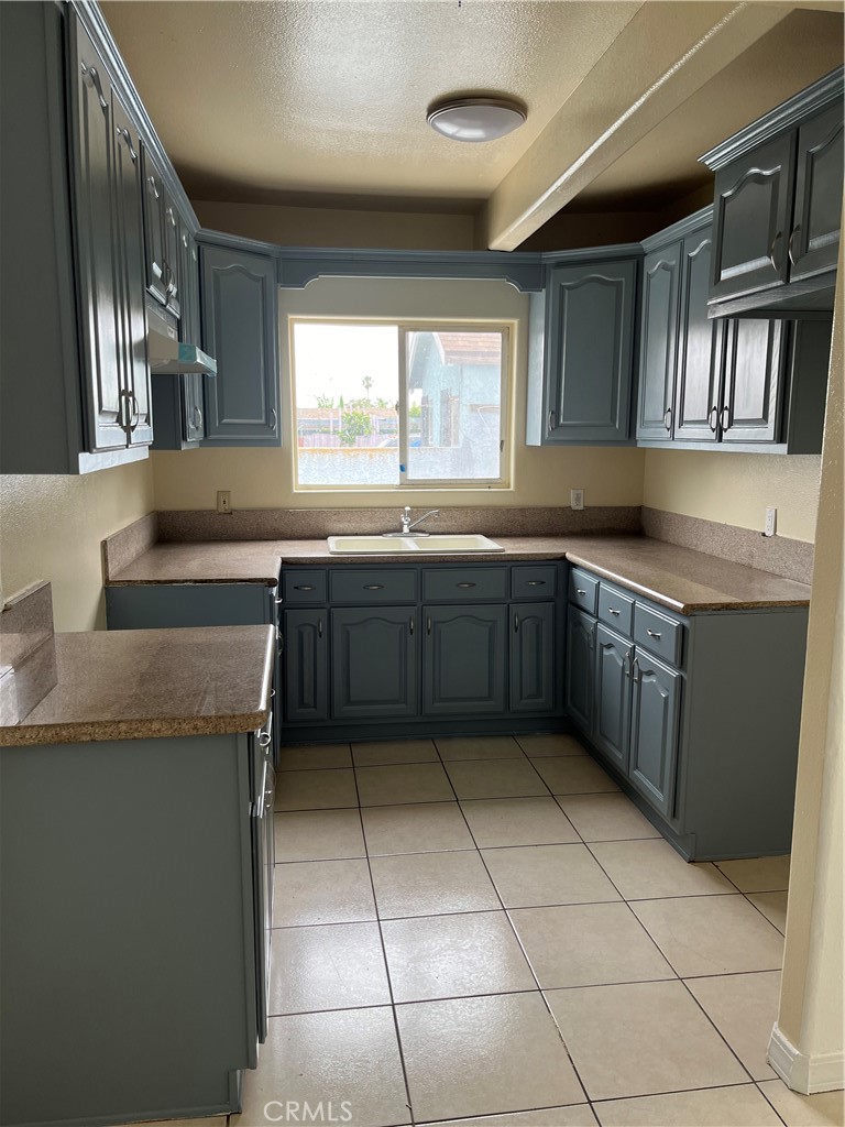 a kitchen with a sink a counter top space cabinets and stainless steel appliances