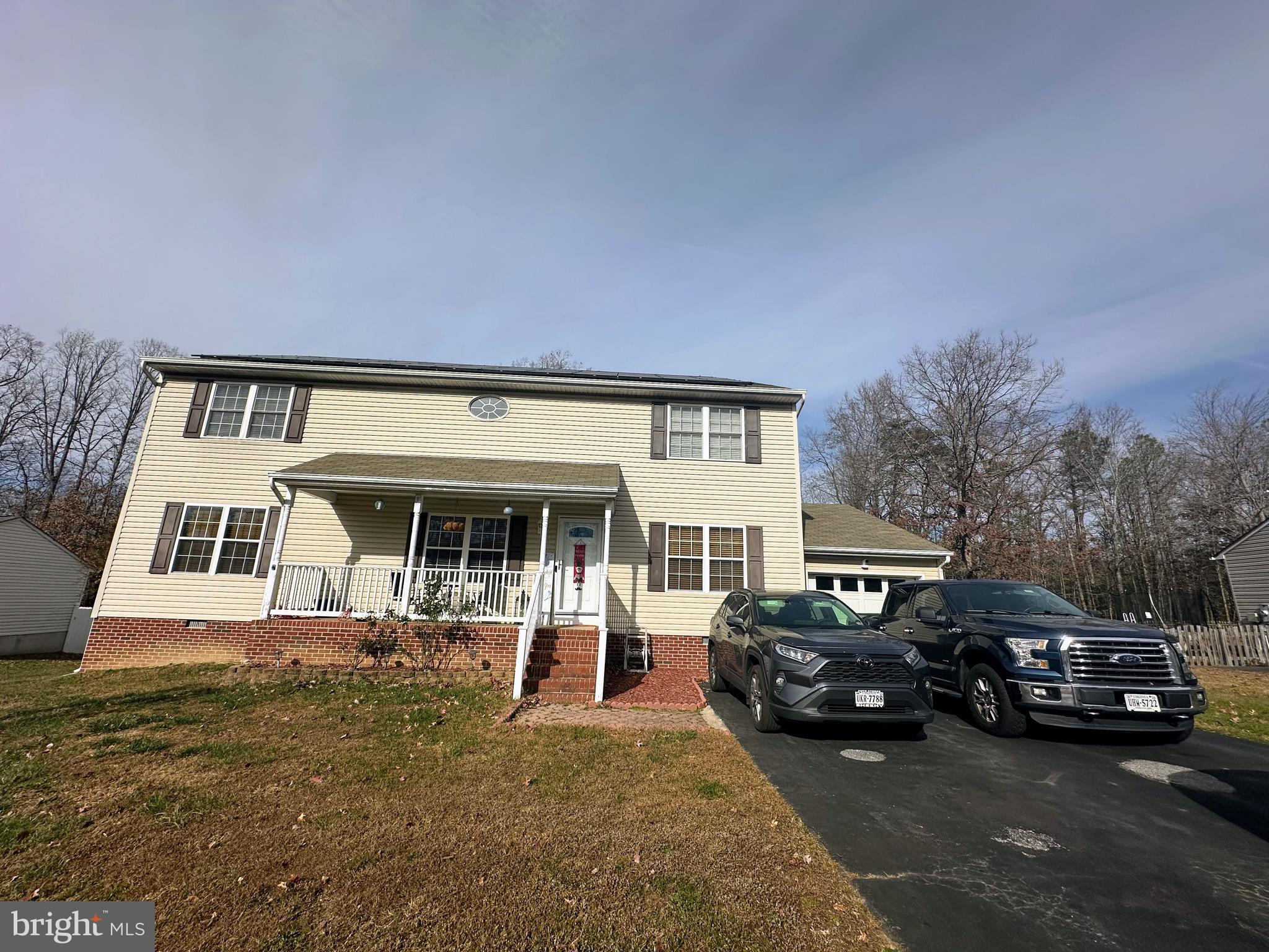 a view of a house with cars parked in front of house