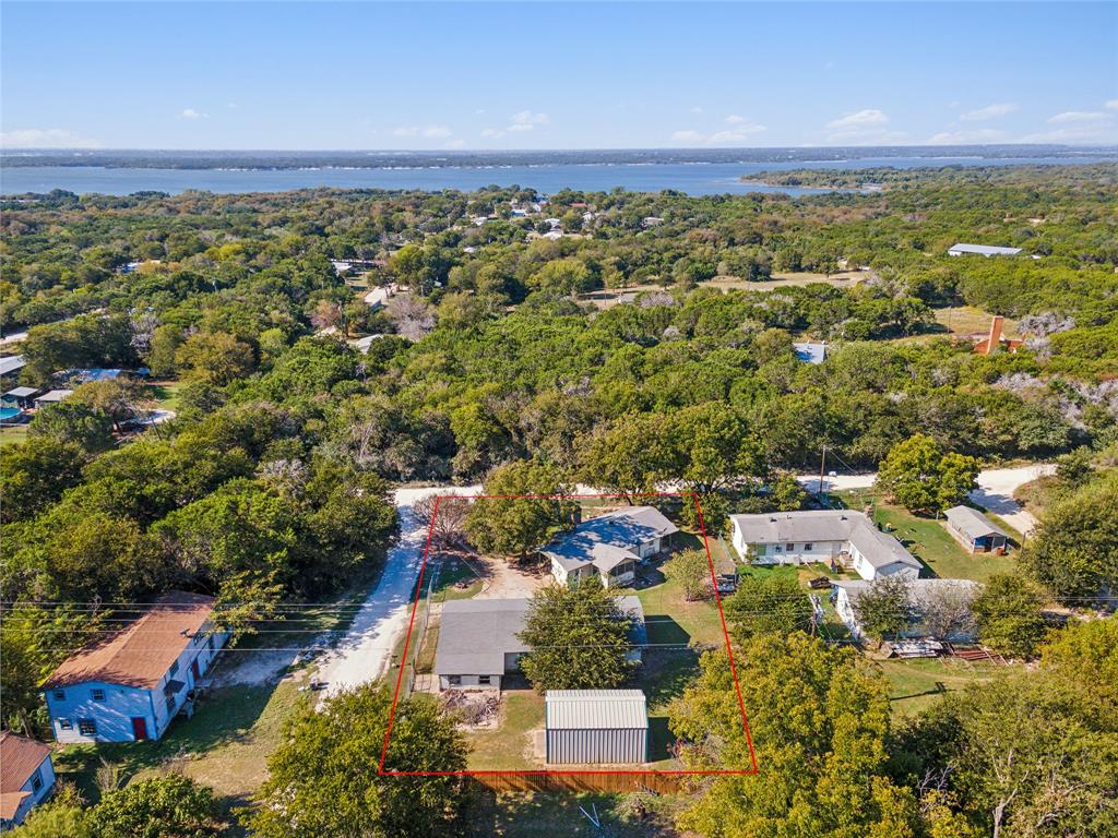 an aerial view of residential houses with outdoor space and trees