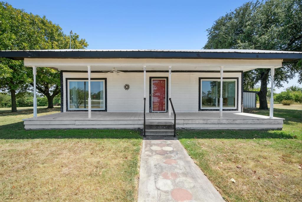 a view of a house with backyard and porch