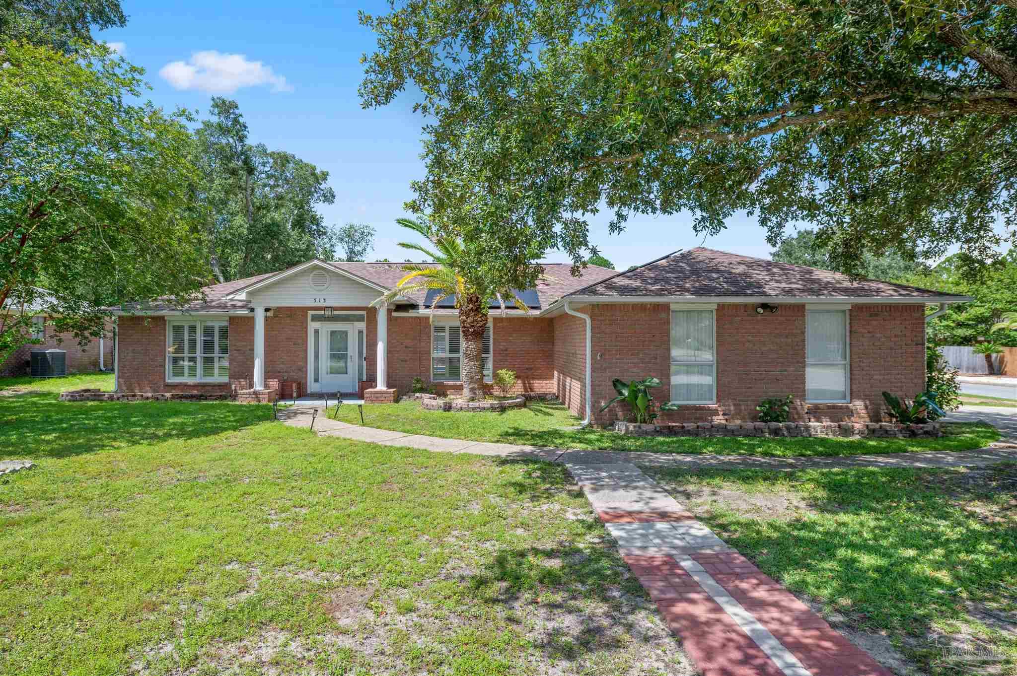 a front view of a house with a yard and trees