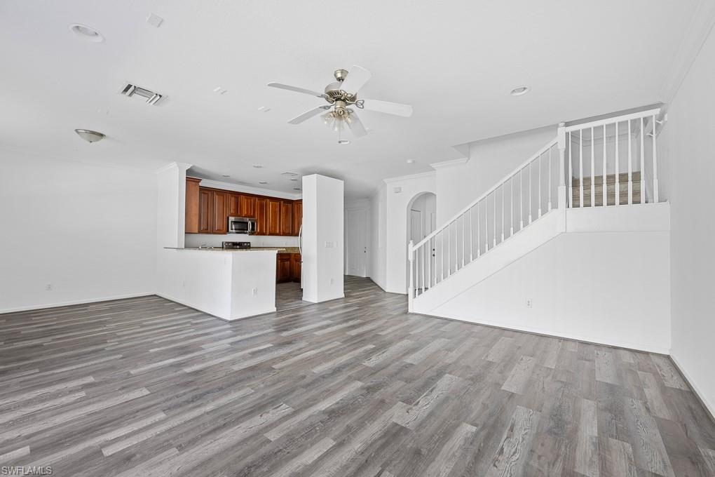 a view of a livingroom with wooden floor and a ceiling fan