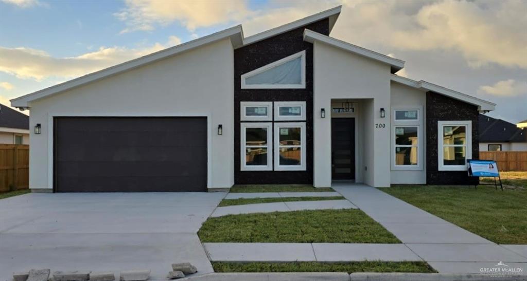 Contemporary house featuring a front lawn and a garage