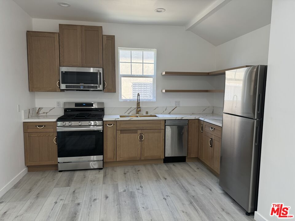 a kitchen with a sink a stove a microwave and refrigerator