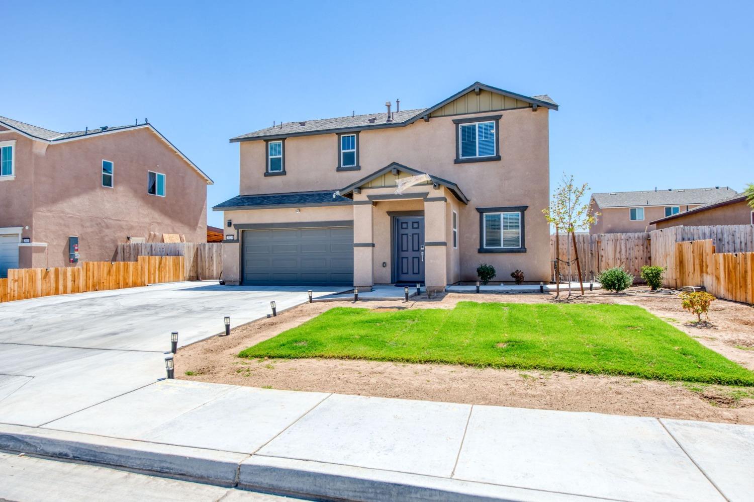 a front view of a house with a yard and a garage