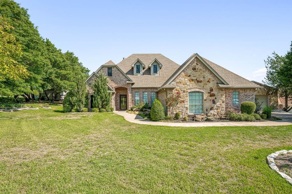 a view of a house with a big yard and large trees