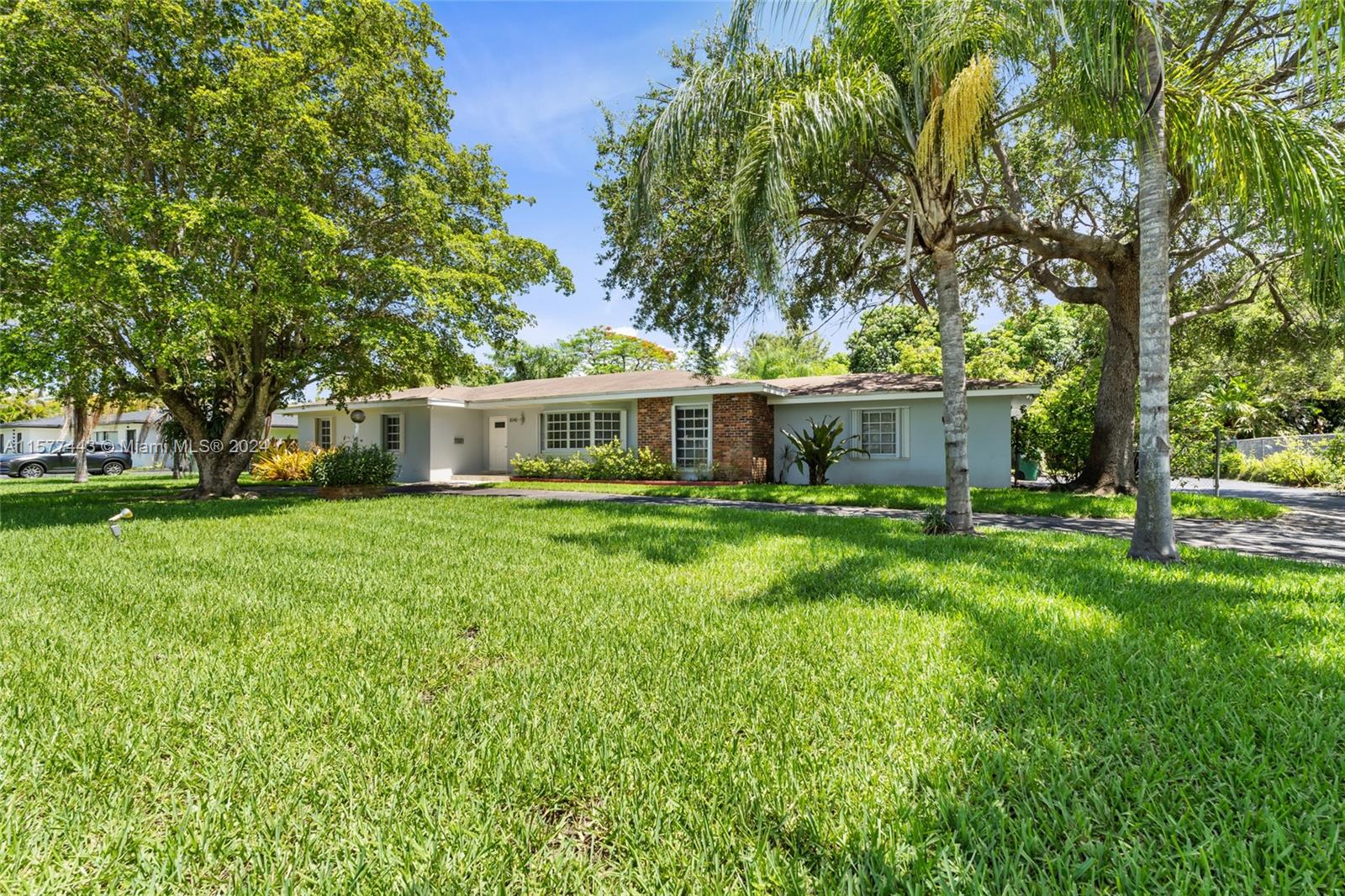 a front view of a house with yard and green space