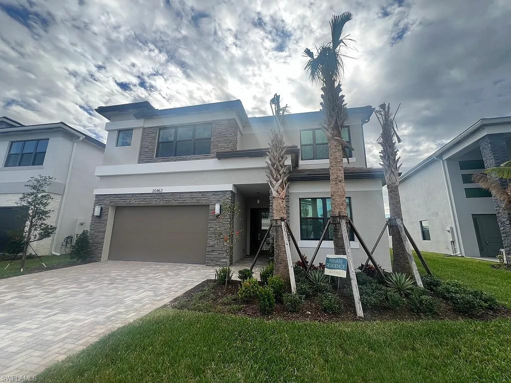 View of front of house with a garage and a front lawn