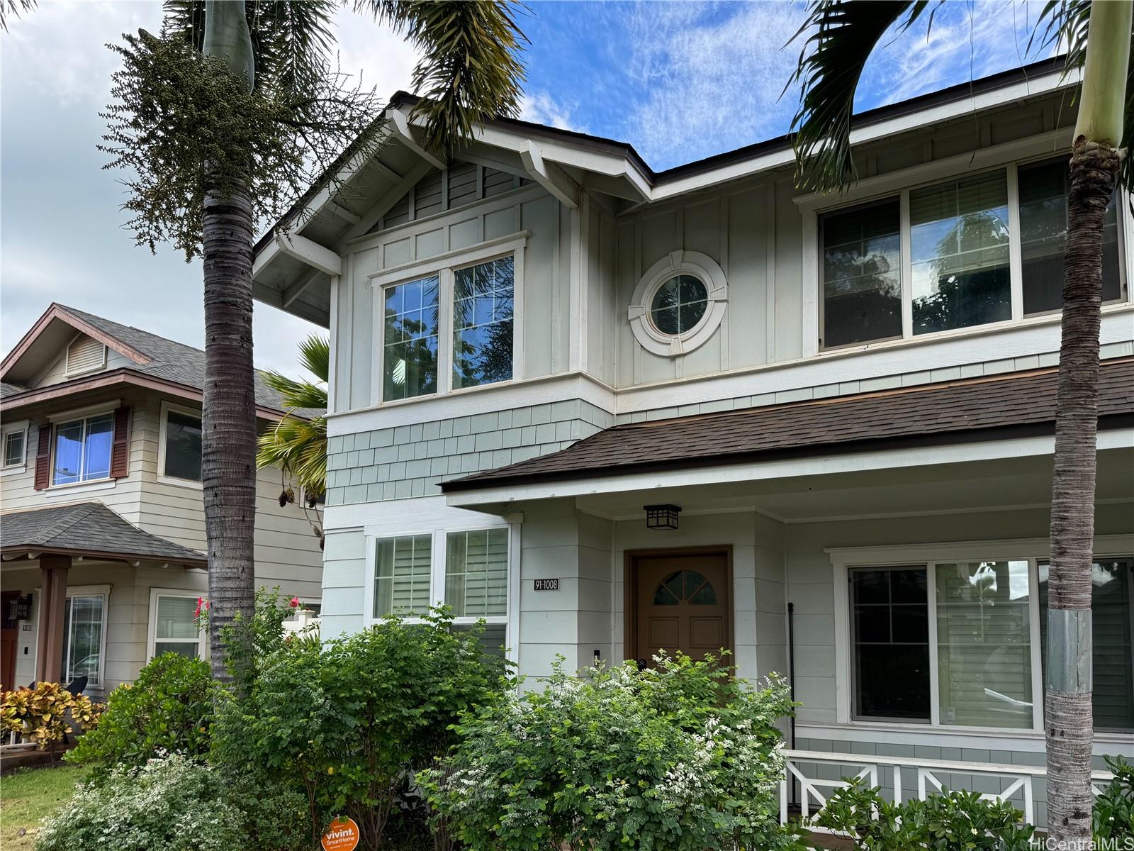 a front view of a house with plants