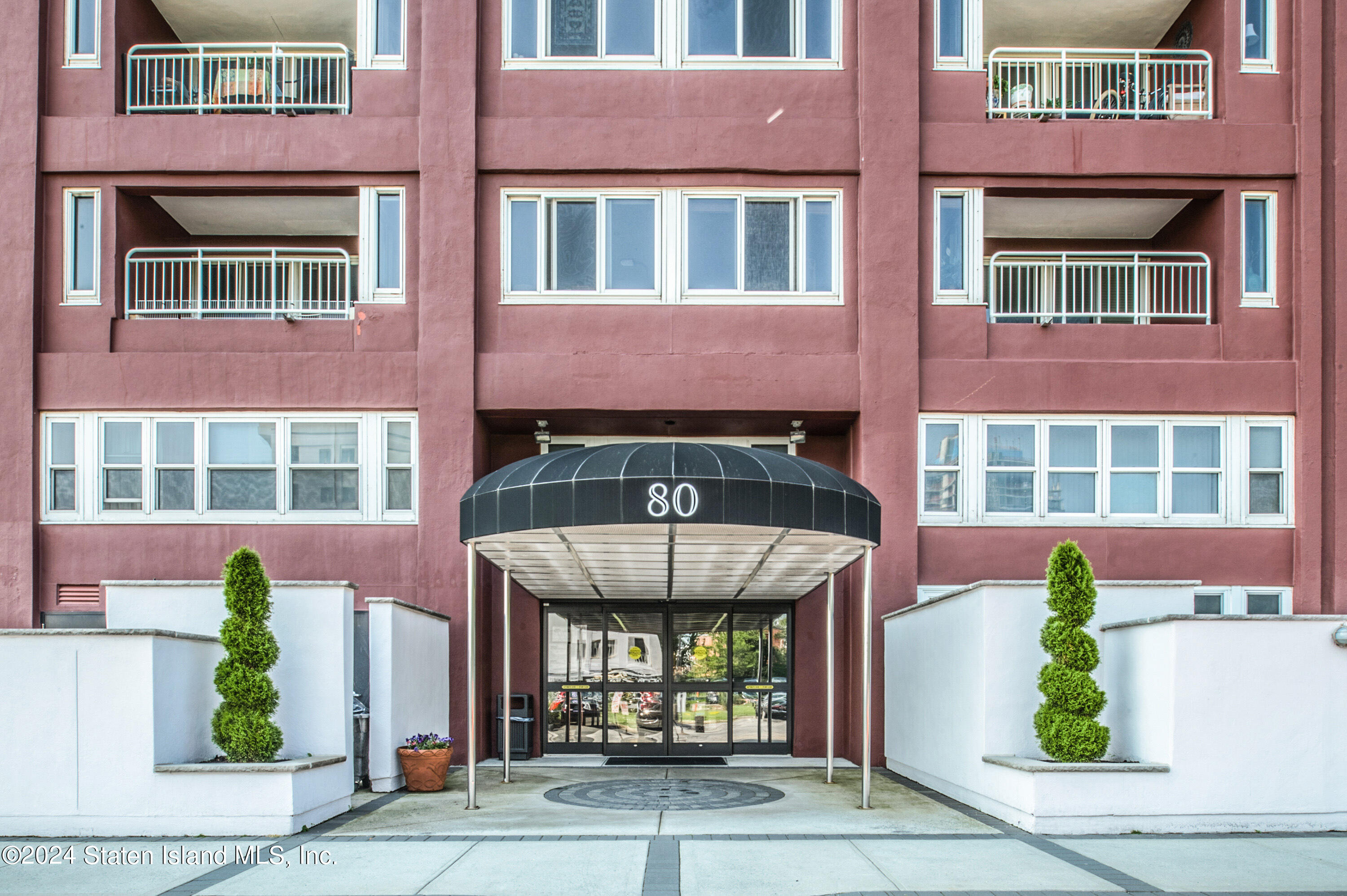 a front view of a multi story residential apartment building with a yard