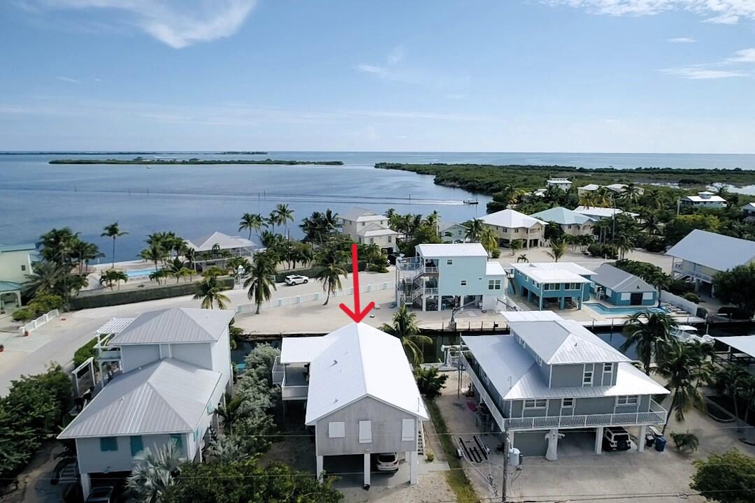 an aerial view of a house with outdoor space and lake view in back