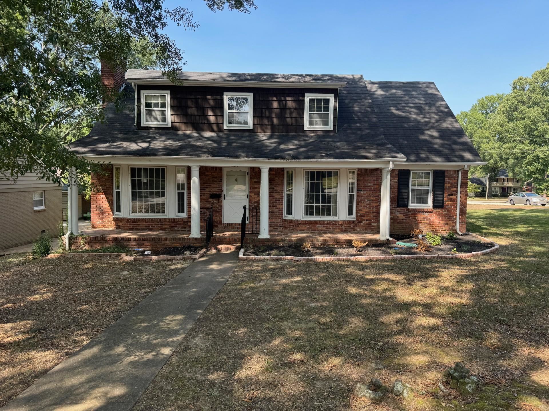 View of front of property featuring a front yard and covered porch