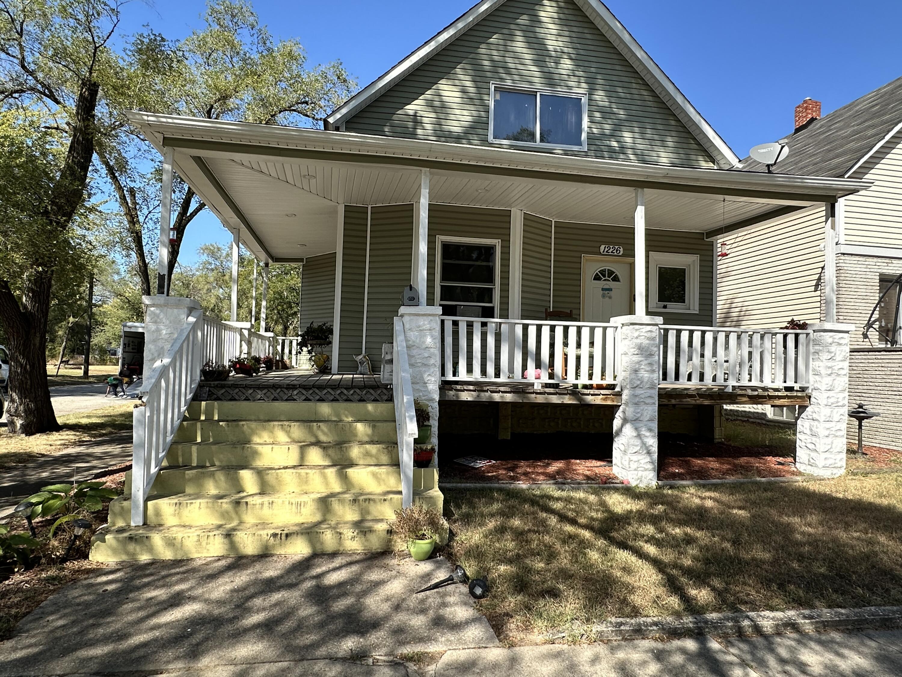 a view of a house with a yard porch and wooden floor