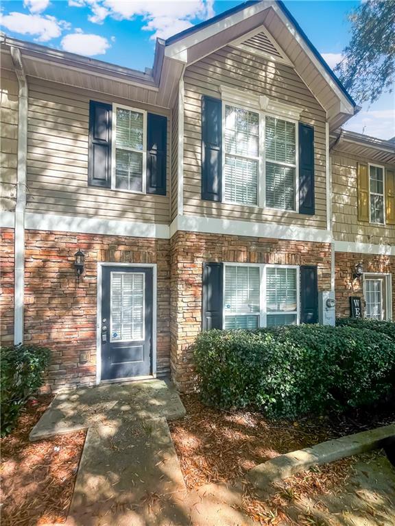 a front view of a brick house with a yard