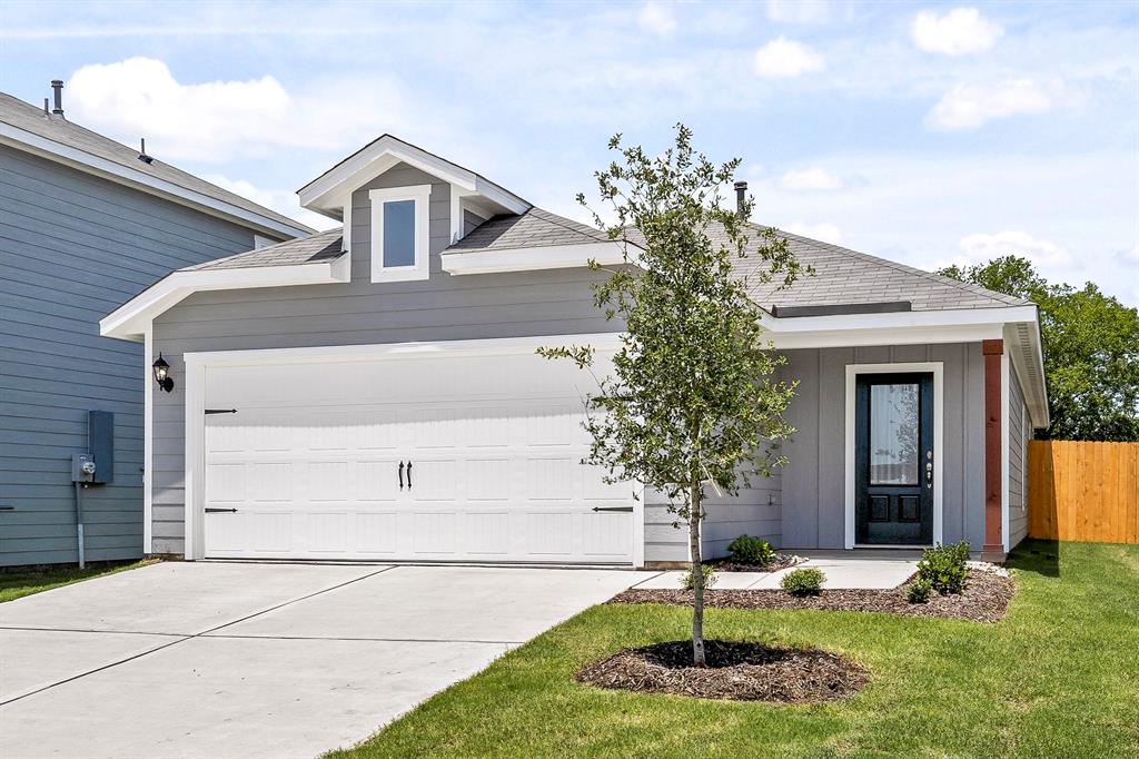 a front view of a house with a yard garage and trees