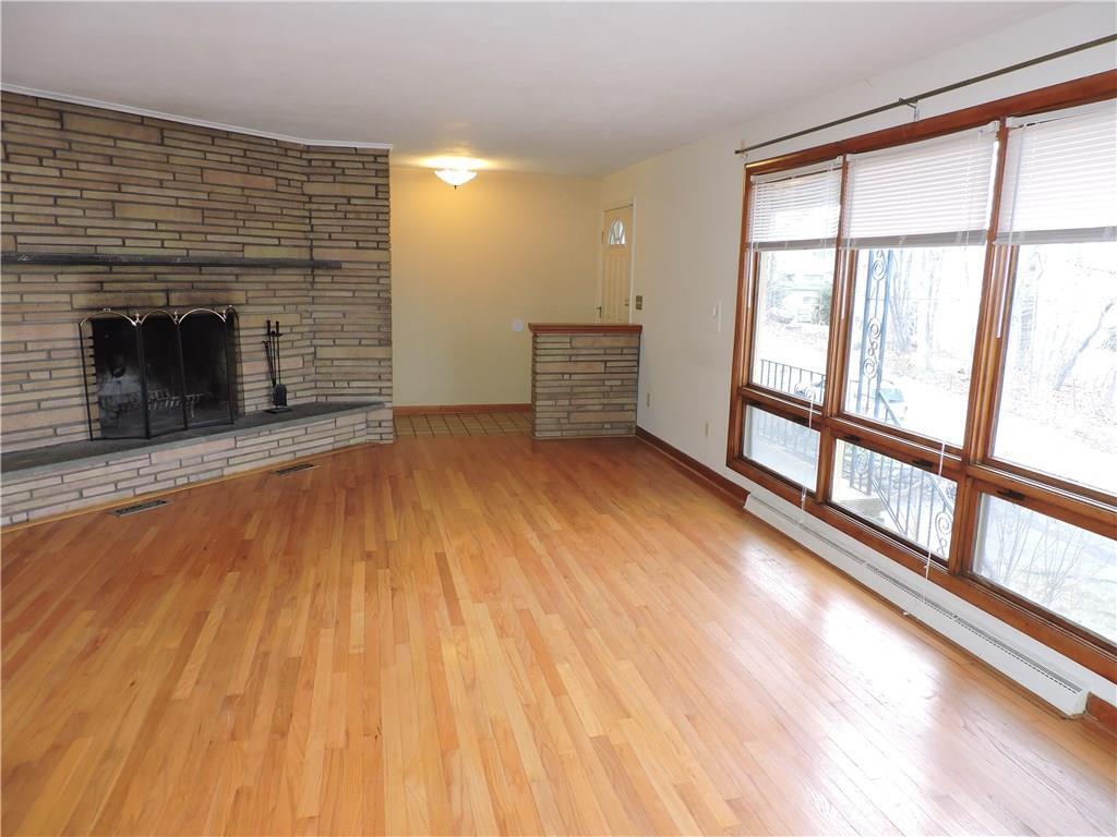 a view of an empty room with a fireplace and a window