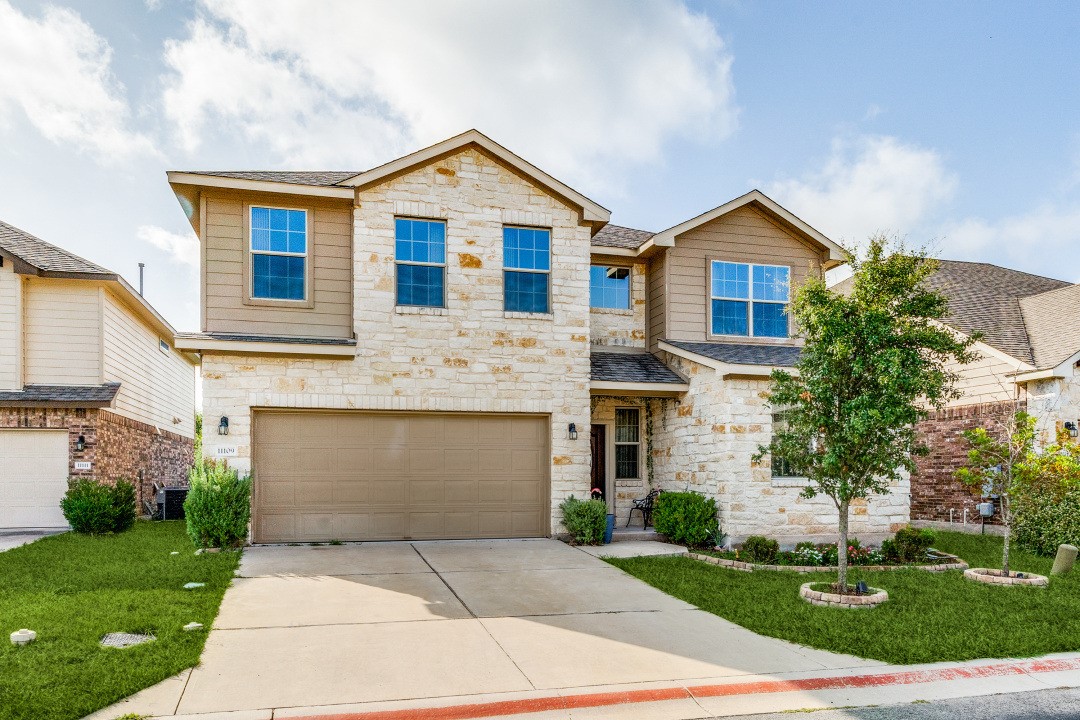 a front view of a house with a yard and garage