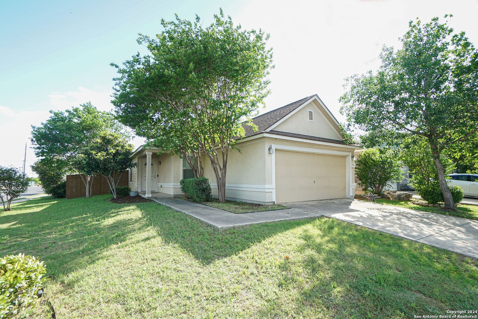 a view of a house with a yard and large trees