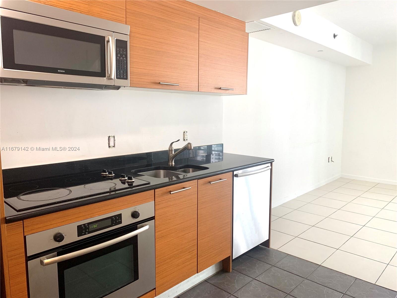 a kitchen with stainless steel appliances a stove a microwave and cabinets