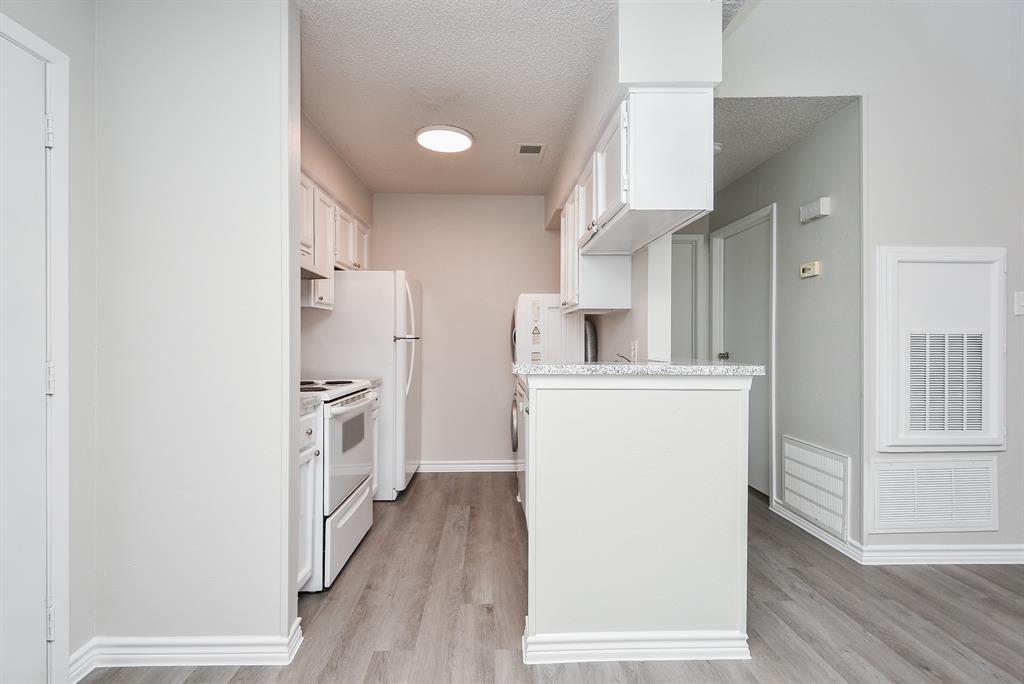 a kitchen with cabinets and wooden floor