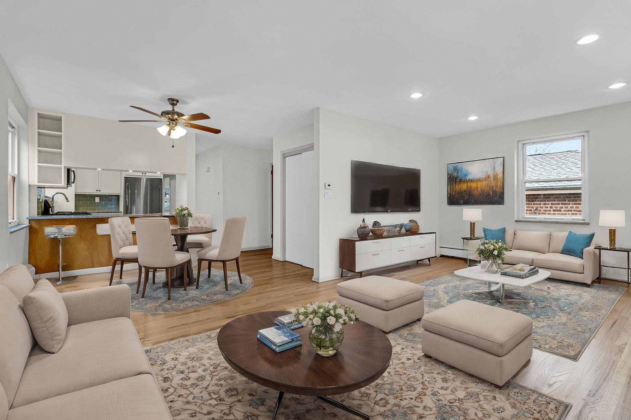 Living room with a baseboard radiator, light hardwood / wood-style flooring, ceiling fan, and sink