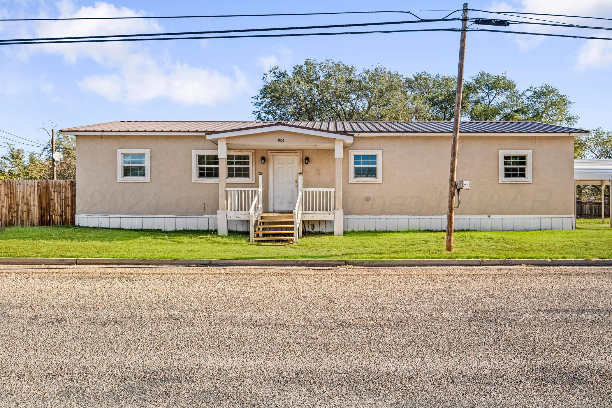 a view of a house with a backyard and a road