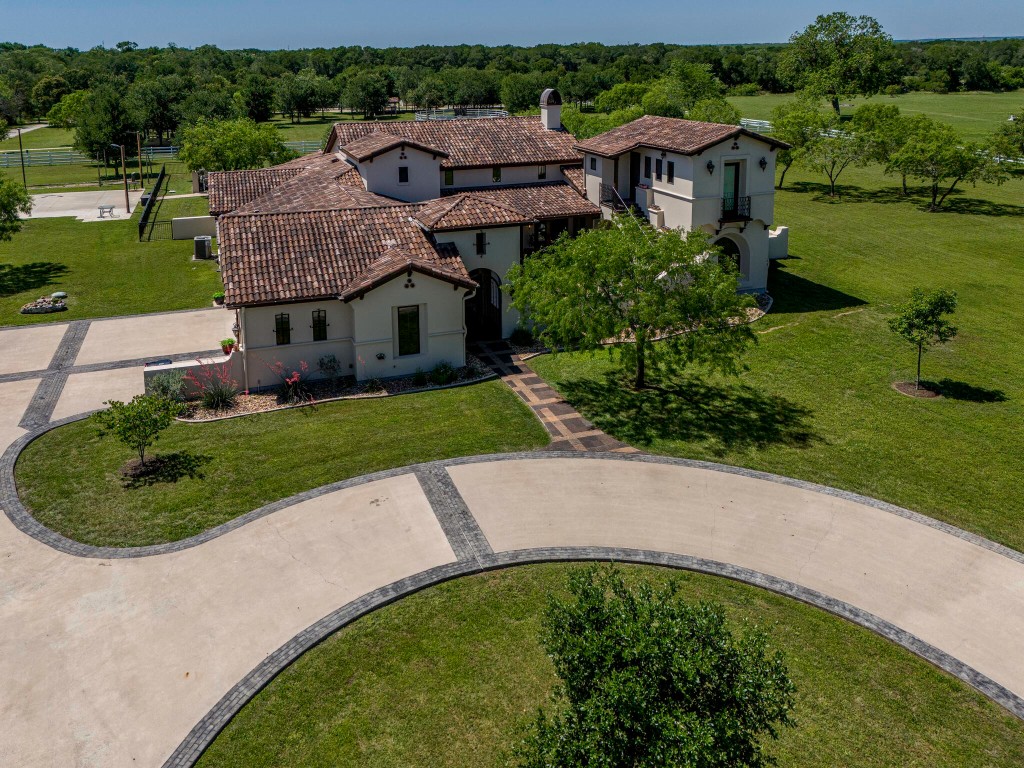 an aerial view of a house with a garden and lake view