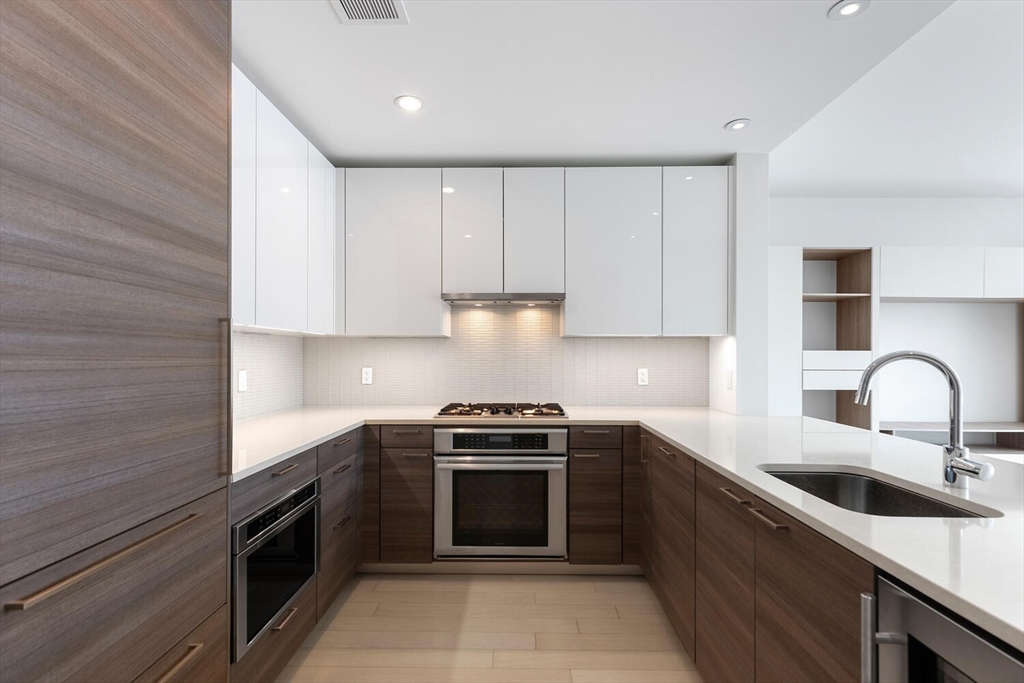 a kitchen with granite countertop a stove sink and cabinets