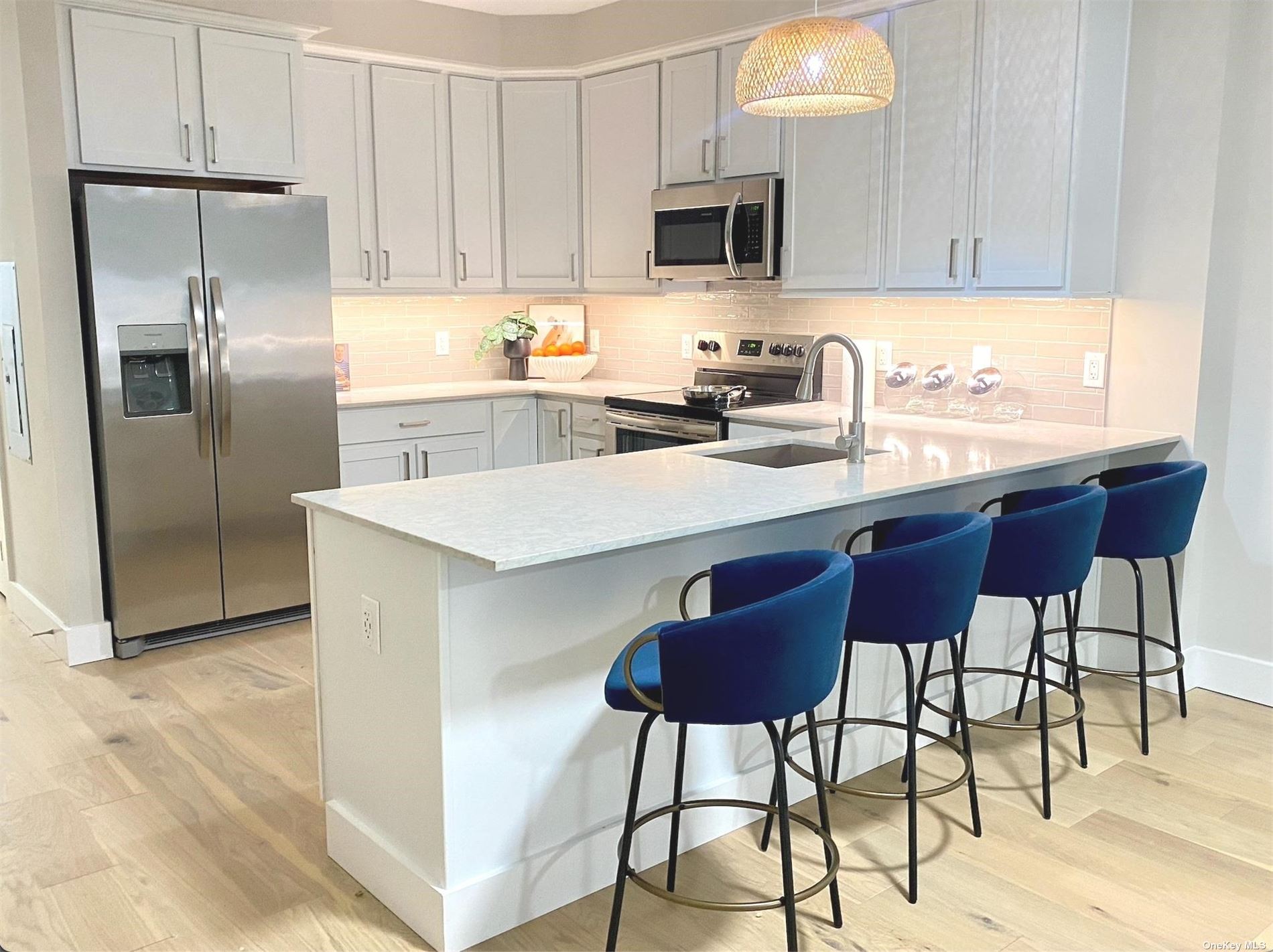 a kitchen with stainless steel appliances a stove a sink refrigerator and a view of living room