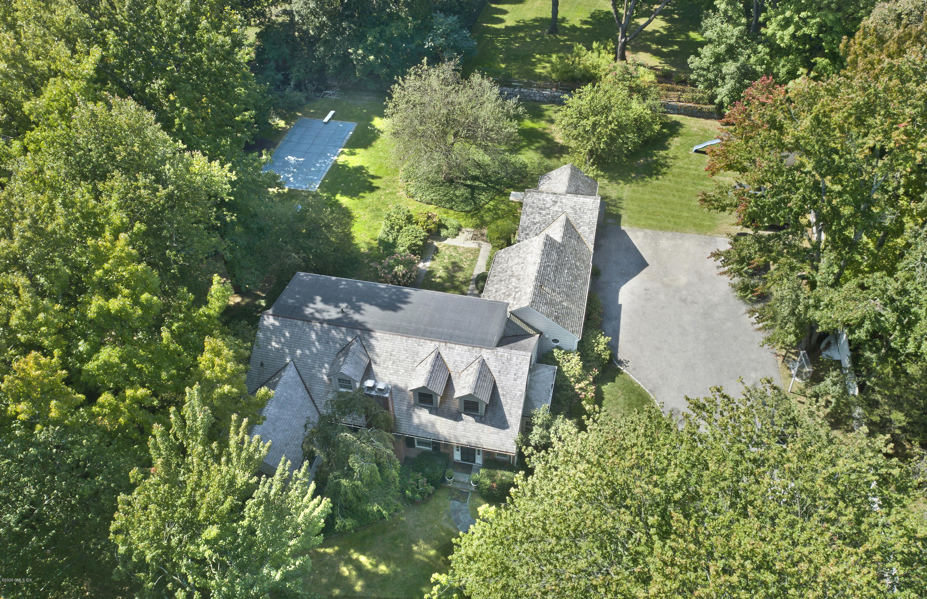 an aerial view of a house with a yard and large trees