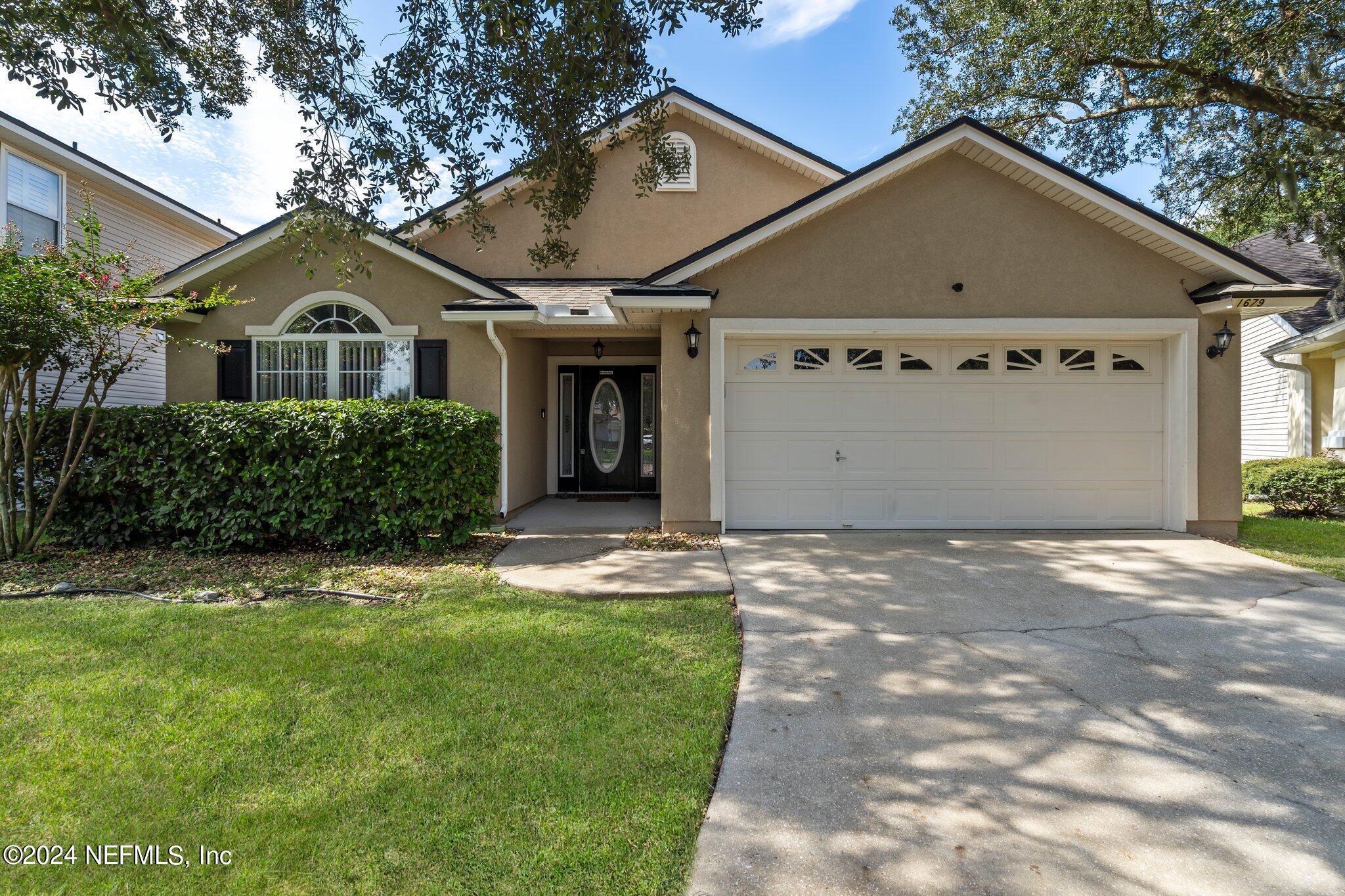 a front view of a house with a yard and garage