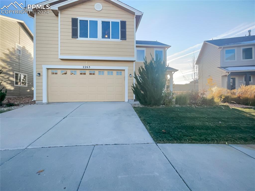 a front view of a house with a yard and garage