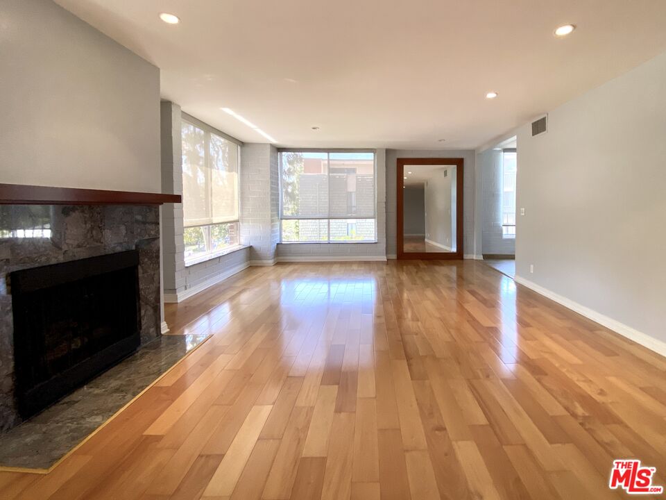 an empty room with wooden floor and fireplace