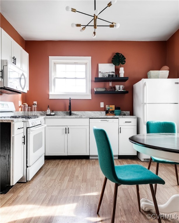 Kitchen with white appliances, light hardwood / wo