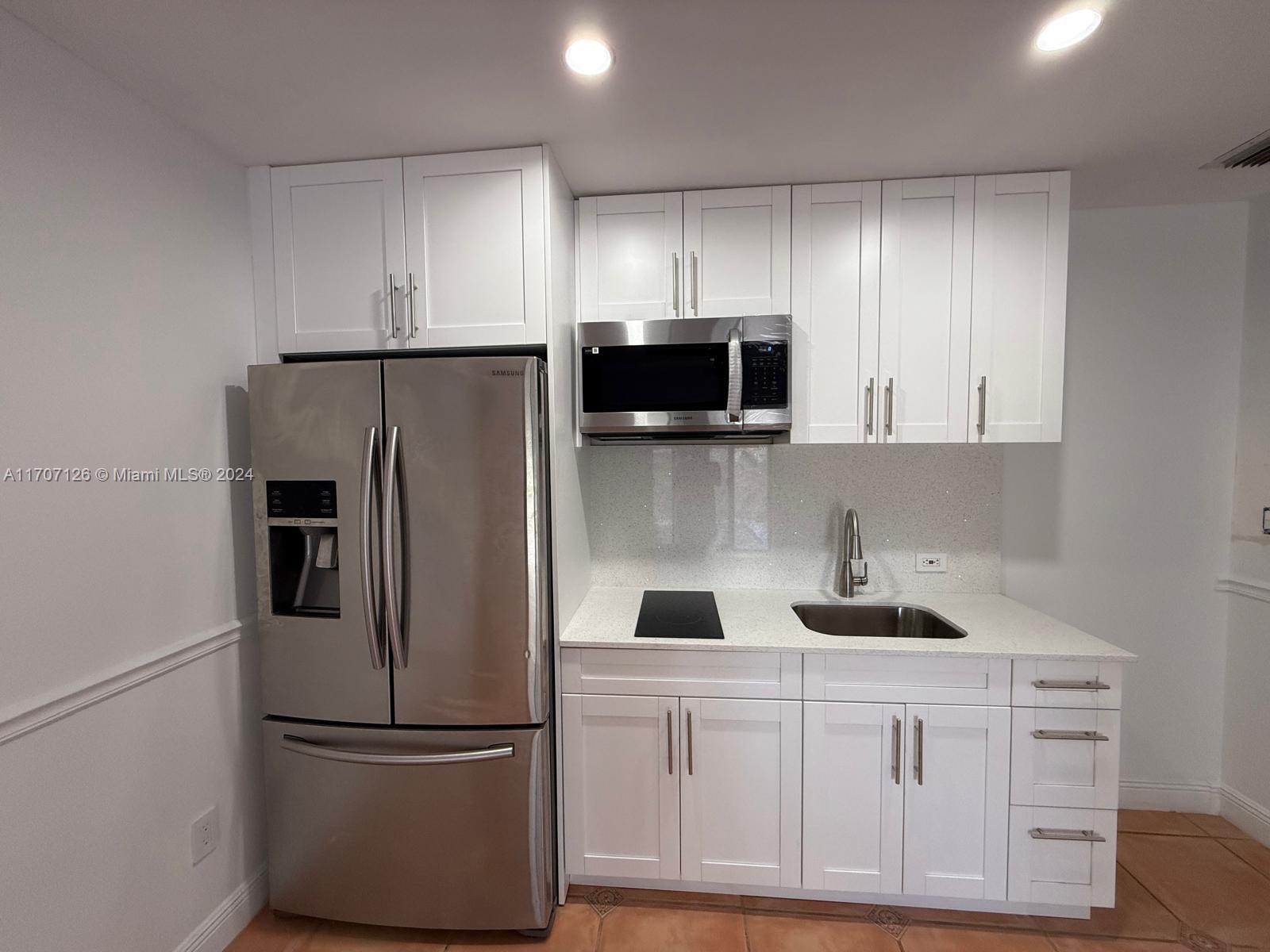 a kitchen with stainless steel appliances white cabinets and a refrigerator