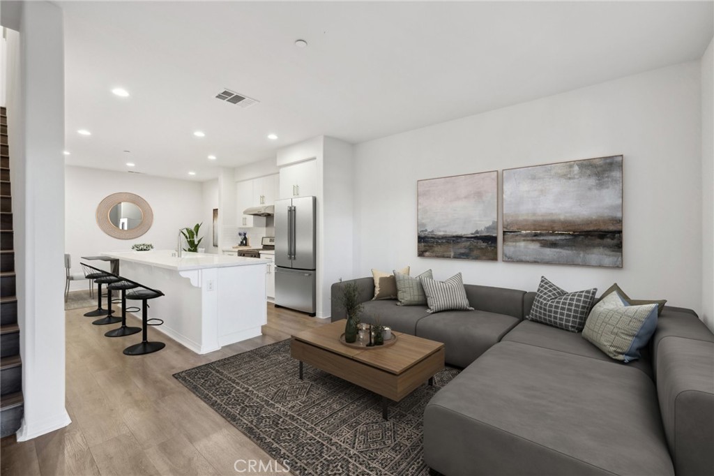 a living room with furniture and view of kitchen