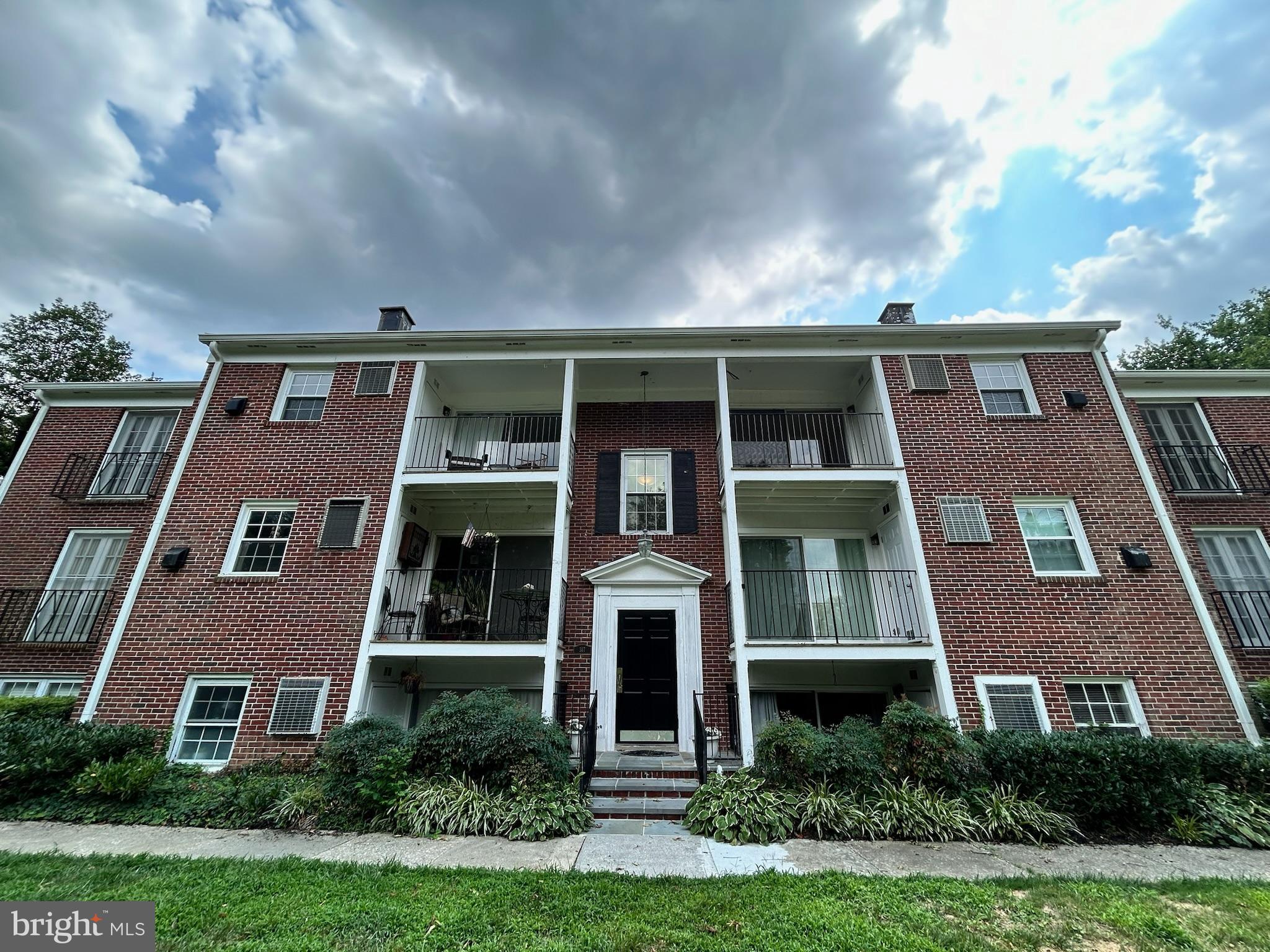 a front view of a residential apartment building with a yard