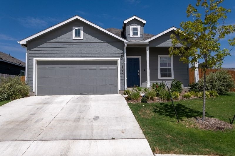 a front view of a house with a yard and garage