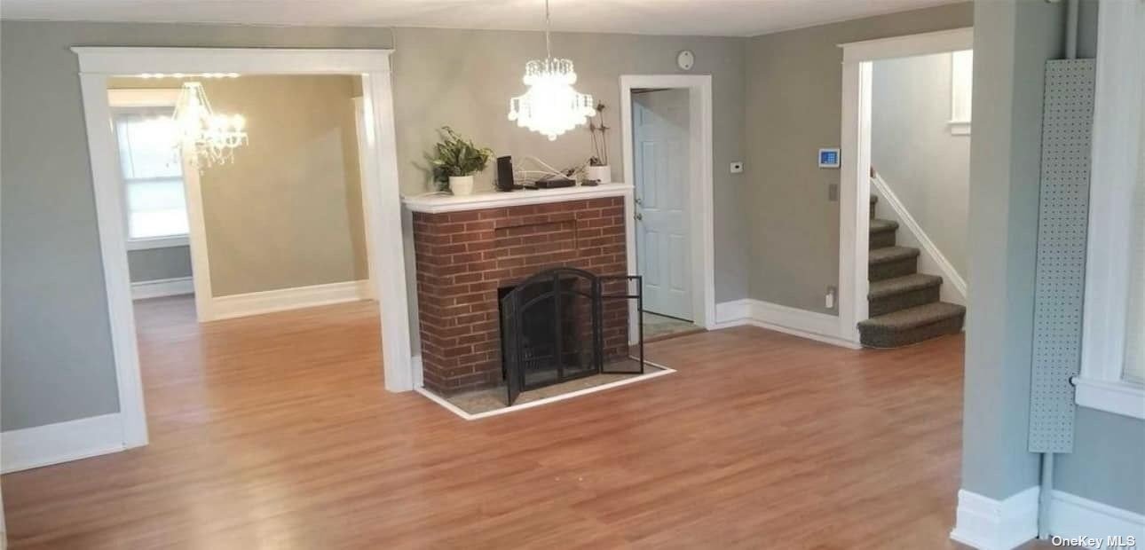 a view of a livingroom with wooden floor and a fireplace