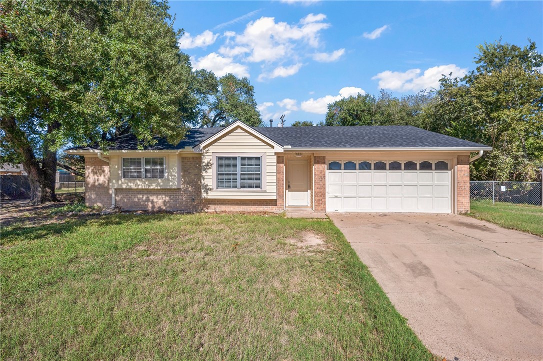 Ranch-style home with a front yard and a garage