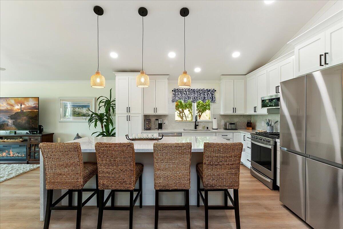 a kitchen with kitchen island a refrigerator a dining table and chairs